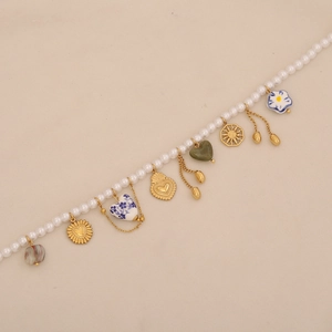 Baroque pearl necklace with colorful heart and sun charms on beige background