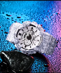 Detail view of waterproof camo sport watch on wet black rock with water droplets
