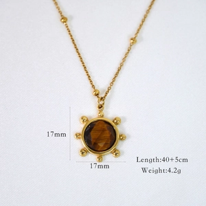 Macro shot of gold sun pendant necklace with tiger eye stone and detailed size measurement