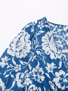 Dettaglio del top con scollo a V, stampa floreale blu e ricamo inglese traforato