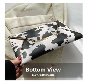 Detail of cow print envelope clutch with elegant gold metal edge trim and sleek finish