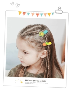 Close-up of cute floral and carrot fabric hair clips on a child's braided hair