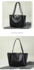 Detail of black pebbled leather tote bag showing dual metal zippers and long shoulder straps