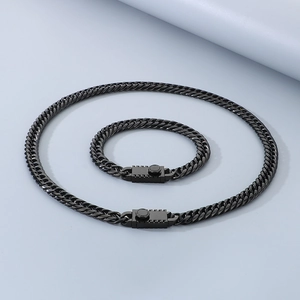 Detail of black stainless steel Cuban link necklace and bracelet set with gear buckle