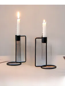 Macro shot of minimalist black metal candle holders with lit spiral white candles