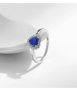Macro view of heart-shaped blue opal ring with diamond halo on silver band
