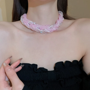 Close-up of pink layered lace beads and pearl choker necklace on a model neck