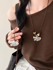 Detail of ginkgo leaf pendant with realistic vein texture on a brown beaded cord necklace