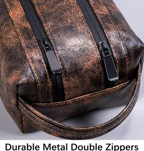 Detail view of durable dual metal zippers and vintage cracked texture on PU leather toiletry bag