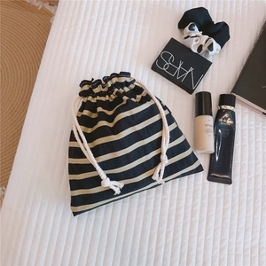 Detailed close-up of striped cotton canvas drawstring pouch for cosmetic storage