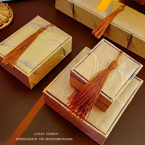 Luxury vintage jewelry boxes with silk texture, gold woven patterns and brown tassels