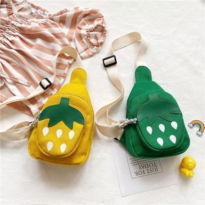 Detail of cute strawberry canvas crossbody bags for girls in yellow and green colors