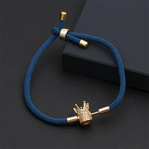 Détail du bracelet tressé bleu avec charm couronne dorée et incrustation de zircon
