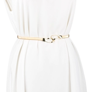 Detail of interlocking buckle on golden metal elastic belt worn on white dress