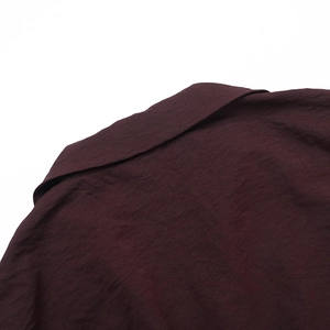 Detail shot of burgundy linen-textured shirt collar showing high-quality stitching and fabric