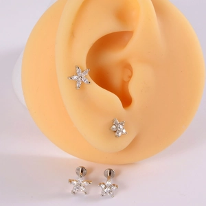 Detailed view of silver flower stud earrings with zircon on silicone ear models