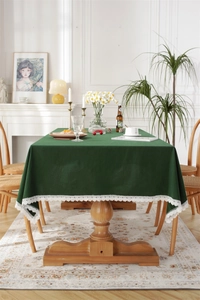 Detail of dark green rectangle tablecloth featuring elegant white lace edges and cotton texture