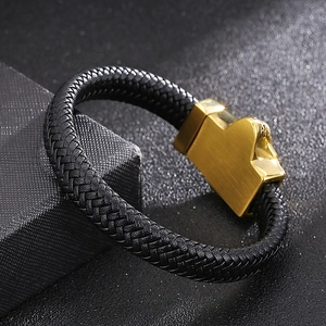 Macro shot of men's black leather braided bracelet with gold stainless steel clasp