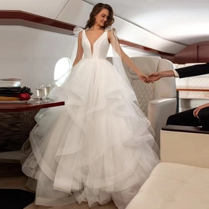 Elegant deep V-neck white wedding dress with sleeveless tulle ruffles and long train