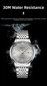 Detail of silver automatic watch with waterproof water splash effect on black background