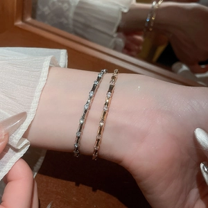 Close-up of gold and silver bamboo style bangles with sparkling zircon stone accents