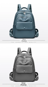 Detail view of blue and grey soft leather backpacks with lychee texture and snap pockets