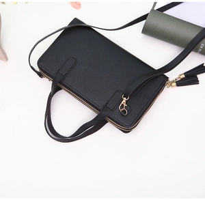 Top view of double-zipper black leather crossbody bag with dual tassels and gold hardware