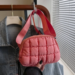 Detail of pink quilted nylon waist bag featuring matching wide strap and zip closure
