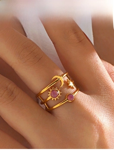 Detail of gold multi-layer ring featuring sun, moon and star charms with purple resin stones