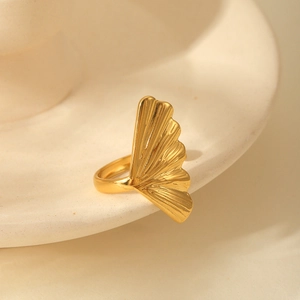 Detailed close-up of golden ginkgo leaf ring with fine textures on ceramic surface