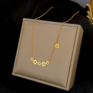 Nahaufnahme der goldenen Gänseblümchen-Halskette auf einem beigefarbenen Schmuckkästchen