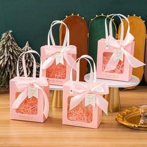 Pink gift bag with transparent window, ribbon bow, and stylish gold lettering tag