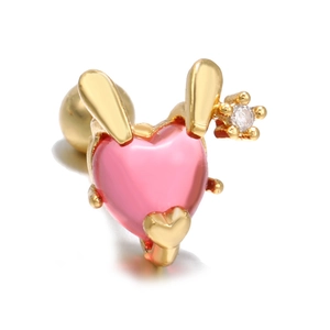 Macro detail of pink heart zircon stud earring with gold rabbit ears and flower accent