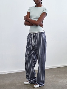 Side view of woman in striped casual trousers with elastic drawstring waist and blue t-shirt