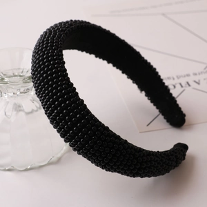 Close-up of a handmade black beaded headband with thick texture and smooth inner lining