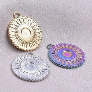 Detailed macro shot of sun-patterned stainless steel pendants in gold, silver, and rainbow