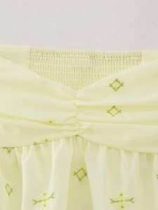 Détail du haut jaune avec broderie verte et smocks élastiques à volants doux