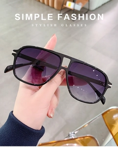 Detail of vintage aviator sunglasses with purple gradient lenses and black resin frames