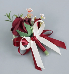 Détail d'une boutonnière en rose PE rouge avec rubans élégants pour mariages