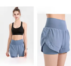 Detail of high-waisted fog blue double-layer sports shorts with brand embossing