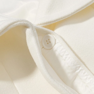Close-up of cream wool coat collar with white resin button and soft fabric texture