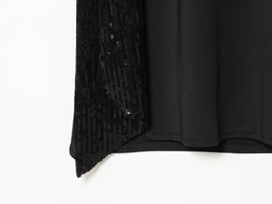 Détail des paillettes noires et des coutures précises sur une robe midi chic