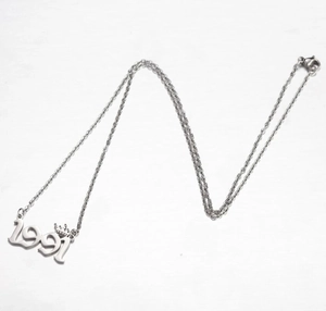 Detailed macro view of silver 1991 year pendant with crown and rope chain