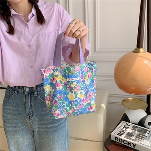Borsa in tela floreale con manici viola mostrata in un ambiente di vita quotidiana