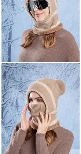 Detail of khaki balaclava with faux fur trim and pom-pom in a snowy winter forest