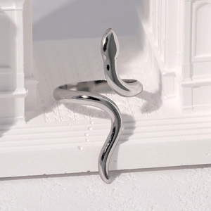 Bague serpent ajustable en acier inoxydable argenté sur un support blanc minimaliste