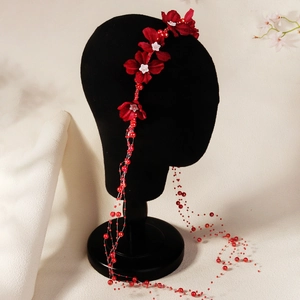 Detail of red floral headband with elegant pearl tassels for wedding hair accessory