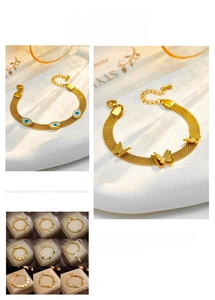 Detail of gold titanium chain bracelet featuring evil eye and butterfly pendants
