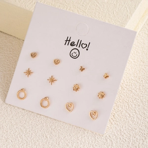 Detail shot of a six-pair golden earring set with heart, star and floral designs