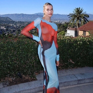 Détail de la robe longue en résille à imprimé abstrait bleu et rouge avec fente latérale